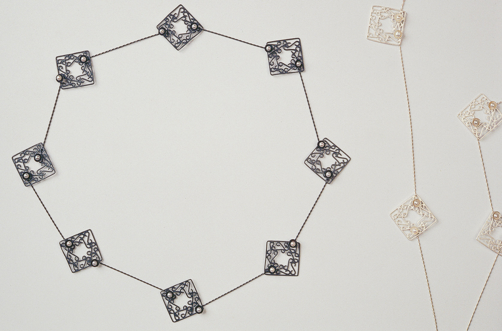 Sita Falkena collier met zilveren hekjes en parels ieder hekje is een slotje zwart en wit